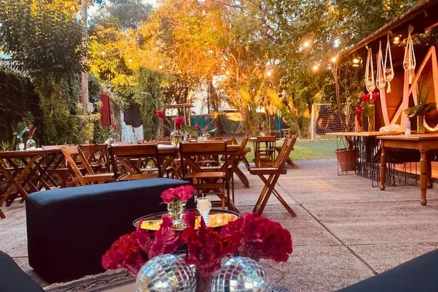 Área externa decorada com globos espelhados e arranjos de flores para festa em Uruguaiana