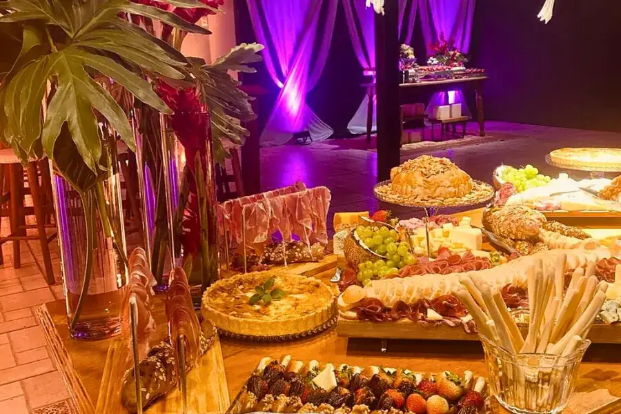 Mesa de buffet iluminada durante festa na área externa em Uruguaiana