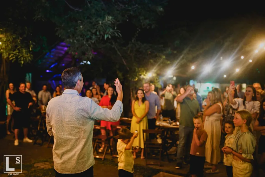 Convidados reunidos celebrando na área externa iluminada em Uruguaiana