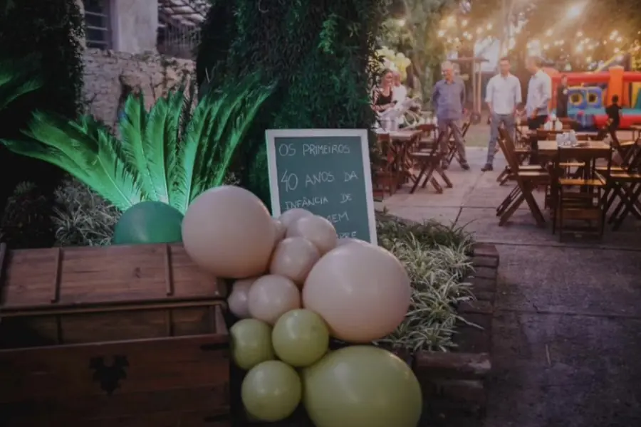 Decoração com balões orgânicos e baú de madeira no espaço de eventos em Uruguaiana