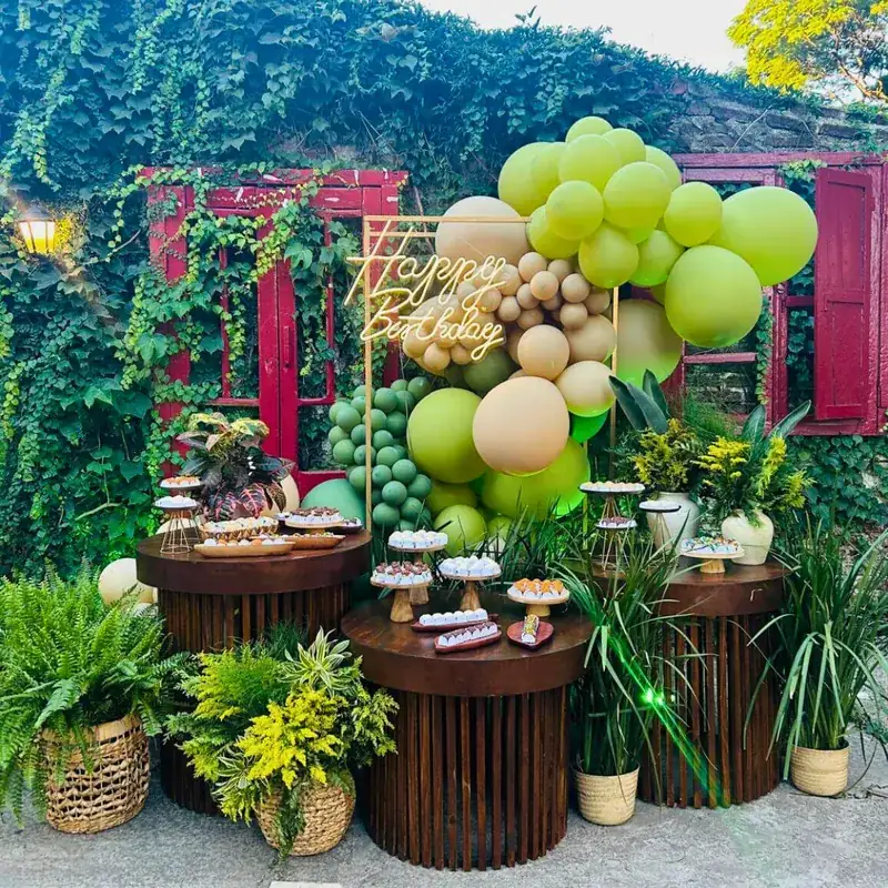 Mesa de aniversário decorada com balões e letreiro luminoso no jardim em Uruguaiana