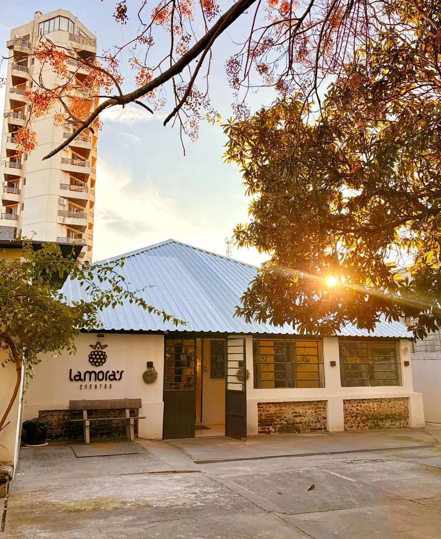 Fachada do Lamora’s Eventos ao pôr do sol, entre árvores, em Uruguaiana