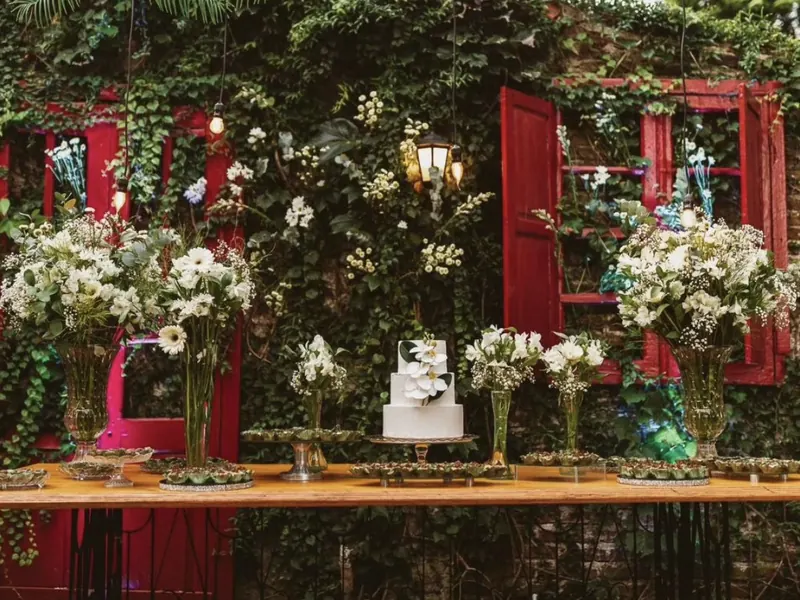 Mesa de bolo de casamento decorada com flores em festa ao ar livre em Uruguaiana