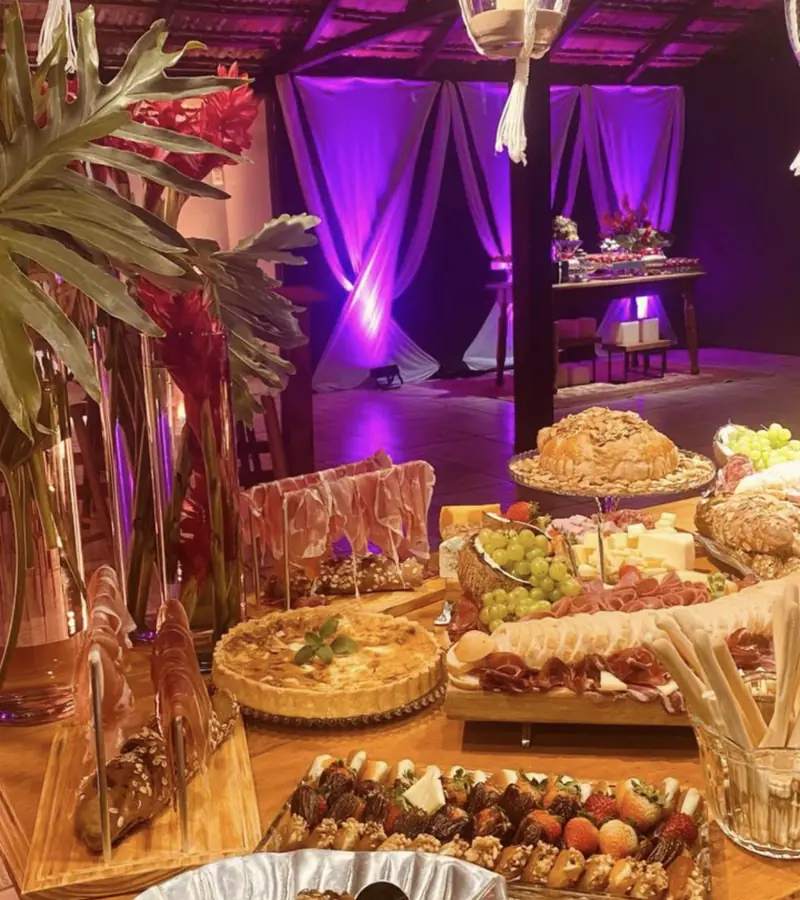 Mesa de comidas sob pergolado iluminado no espaço de eventos em Uruguaiana
