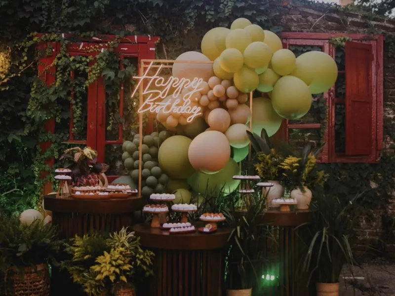 Mesa de doces com balões e letreiro neon para festa de aniversário em Uruguaiana